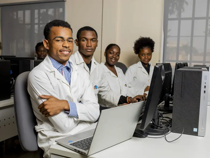 Alunos de bata branca na sala de informática