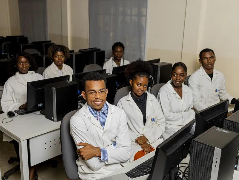 Sala de informática do Instituto, com alunos de bata branca nos computadores