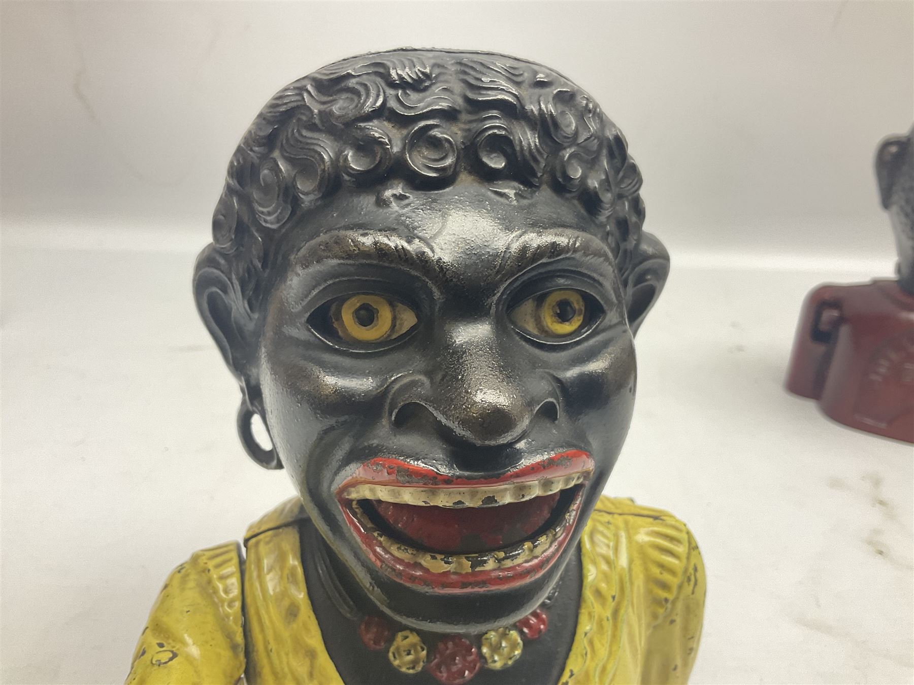 Three early 20th century cast-iron mechanical money banks as a