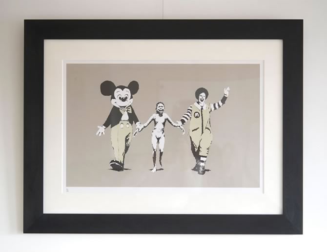 Banksy（バンクシー） “Napalm” を額縁「WALNUT Black」で額装してい