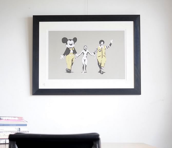 Banksy（バンクシー） “Napalm” を額縁「WALNUT Black」で額装してい