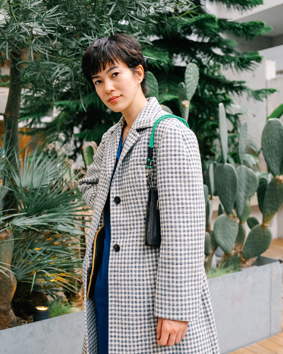 あざやかなブルーのジャンプスーツを主役に、チェックコートをあわせて