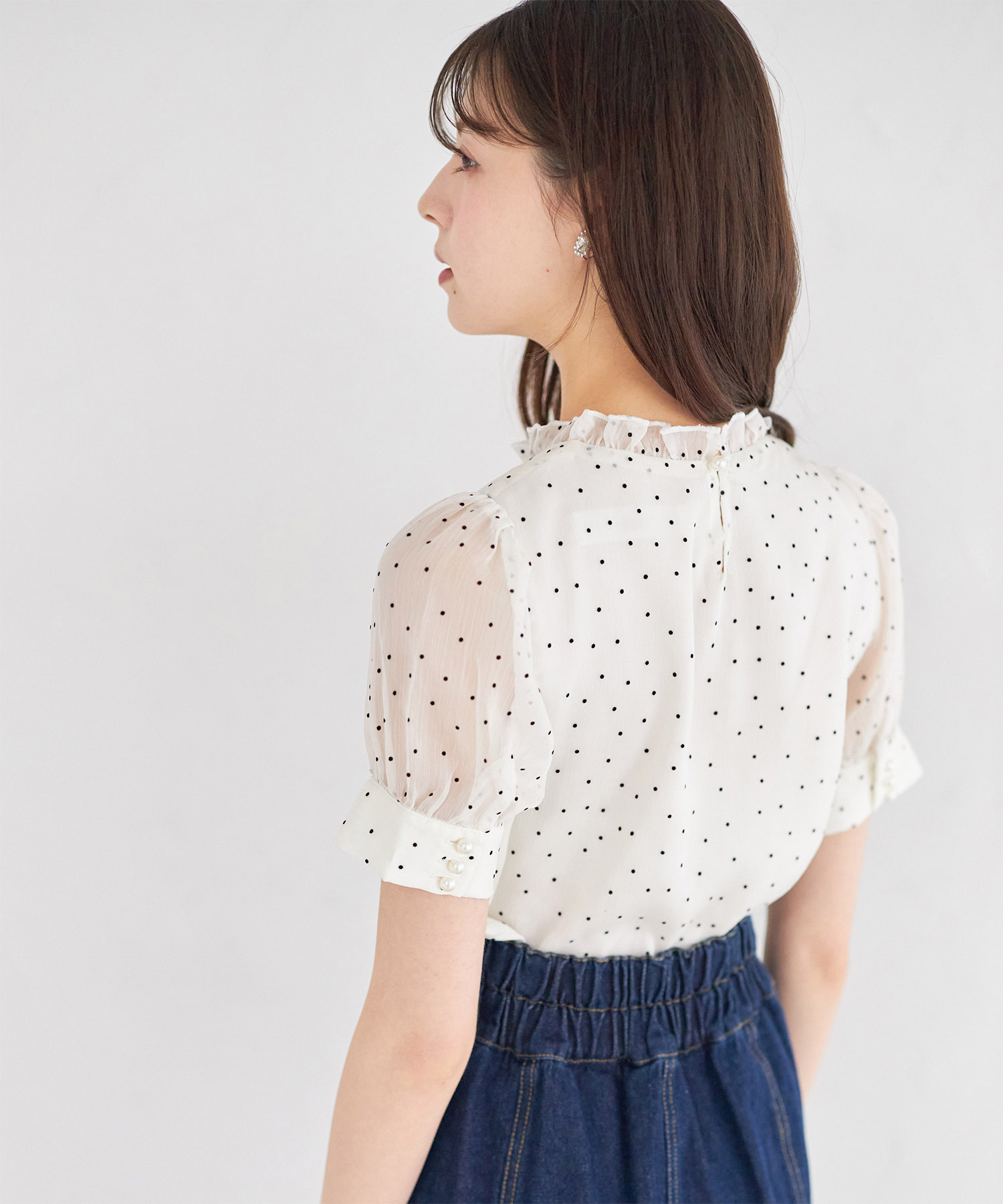 シアーな表情が今っぽいプチフリルネックパール釦フロッキードットブラウス