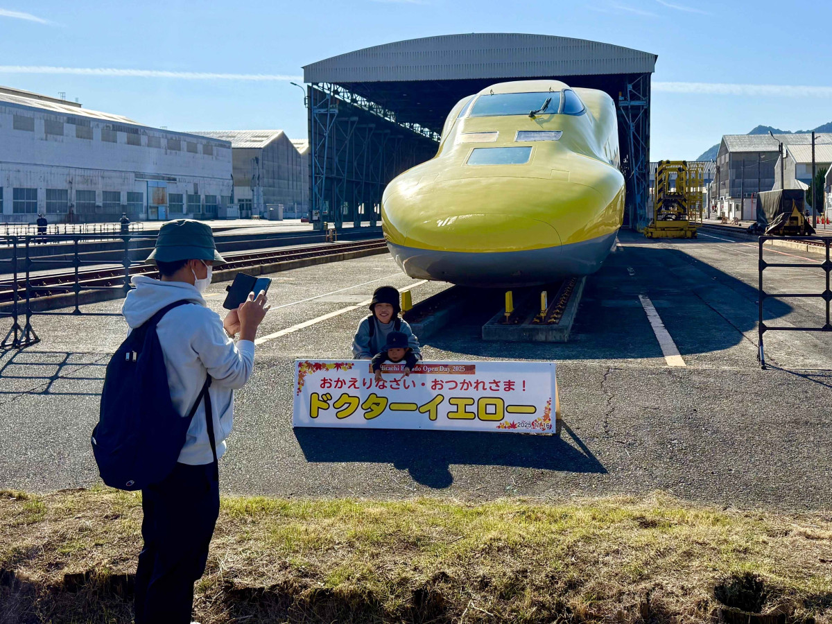 ドクターイエロー」T4編成の先頭車両と記念撮影する来場者（日立製作所