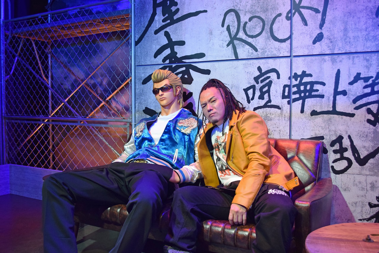 鈴蘭高校の屋上を再現したフォトスポットに座るやべきょうすけ。 [画像