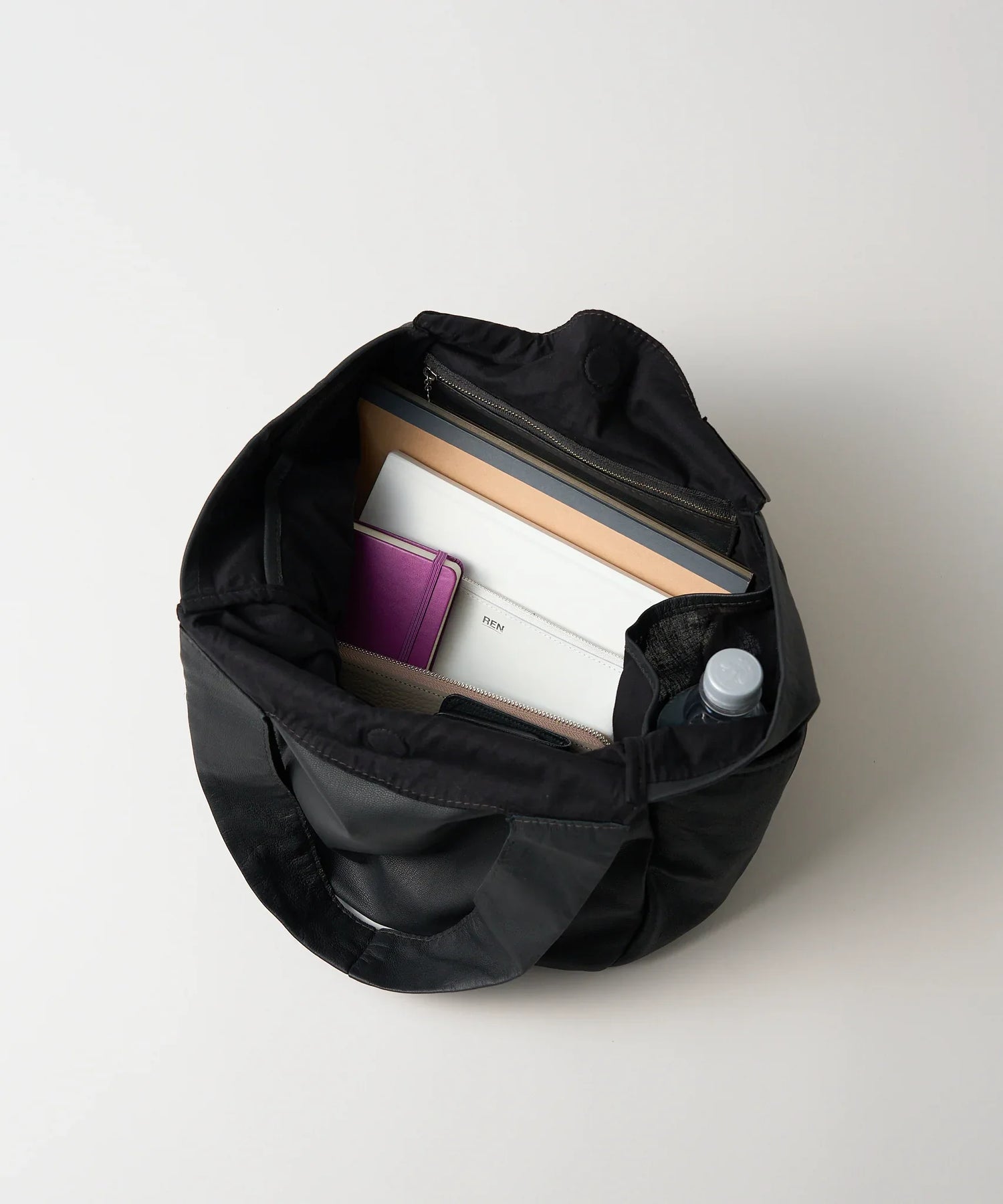 ポケット豊富で容量多めの丸型やぎ革バッグ - 幅広ハンドルで快適な