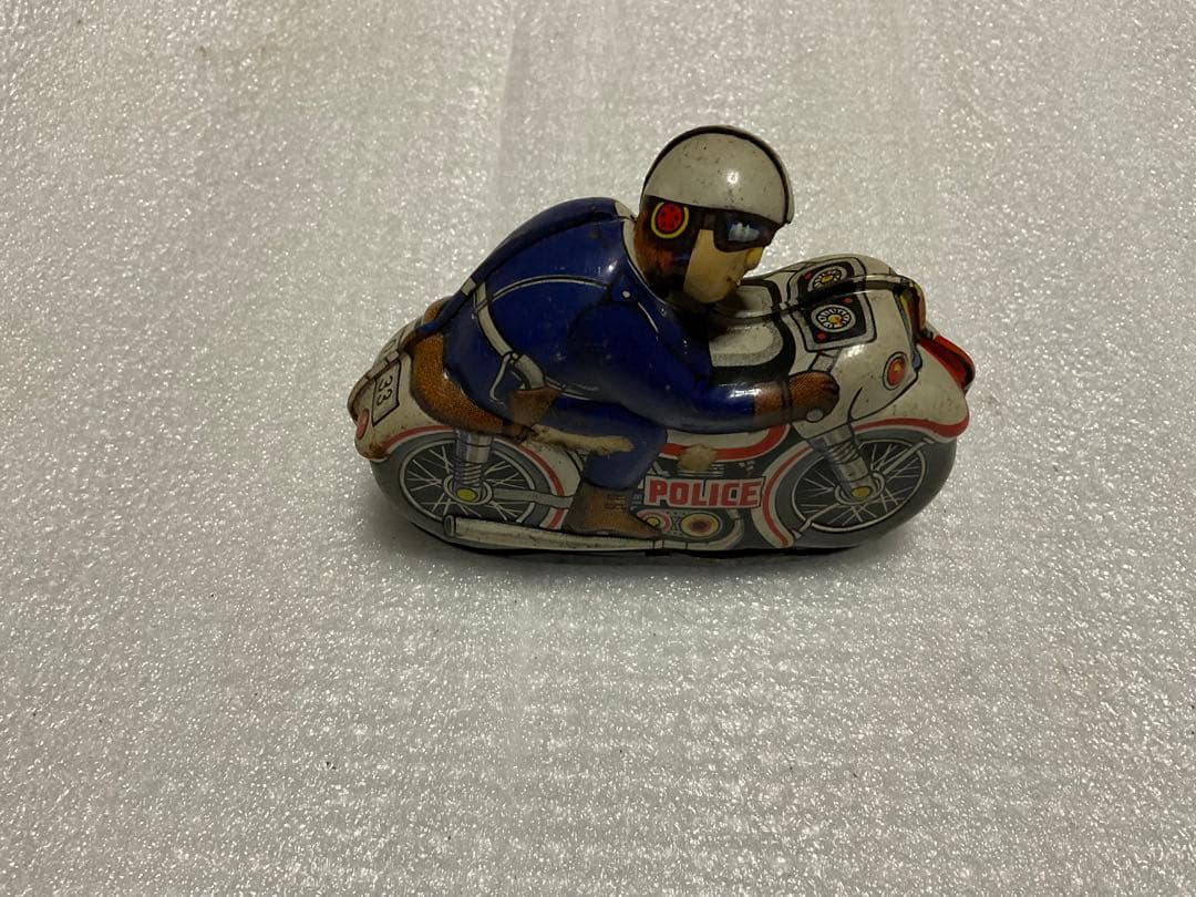 ブリキ製・クルクルゼンマイポリス。【首が動きます。走行します。多少汚れあり】。