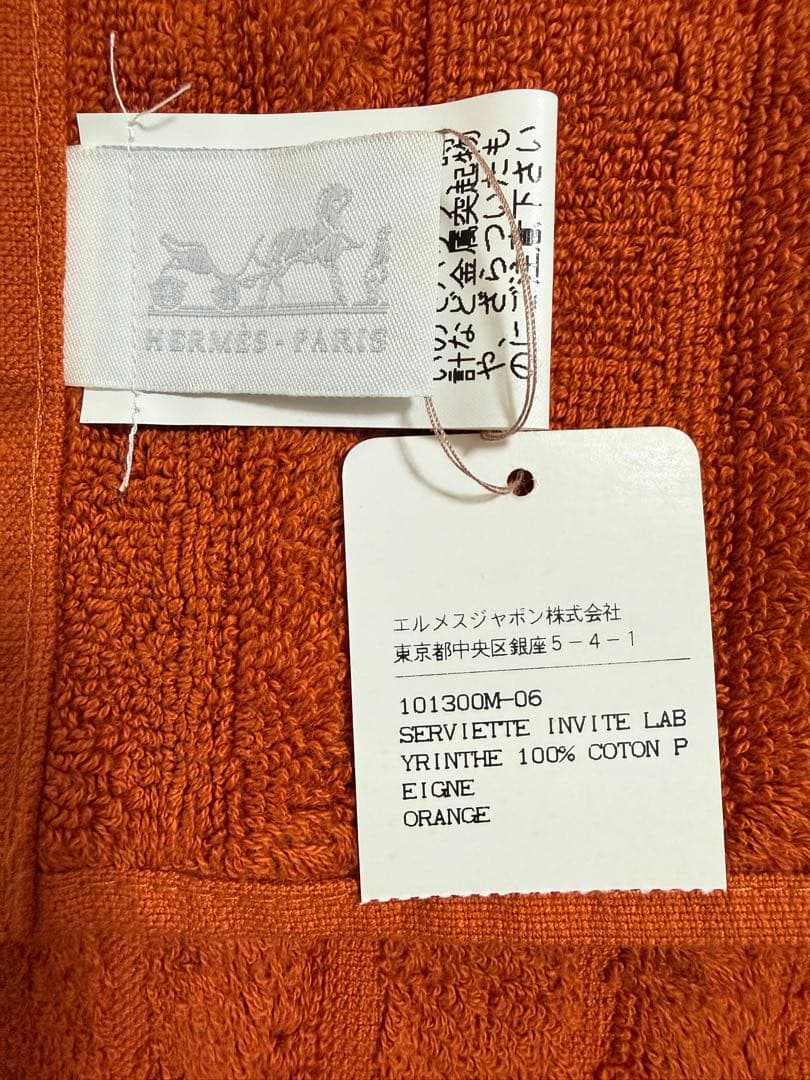 エルメス（HERMES）のHロゴ入りデザインのオレンジ色のコットン