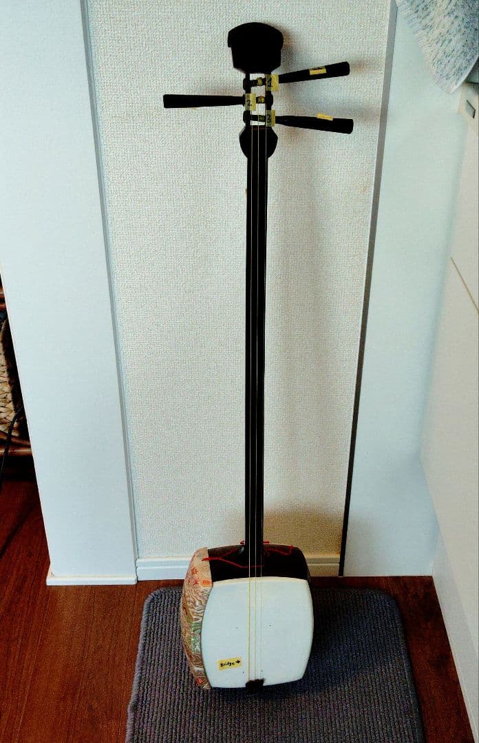 白い三味線とケース付きの標準サイズです。