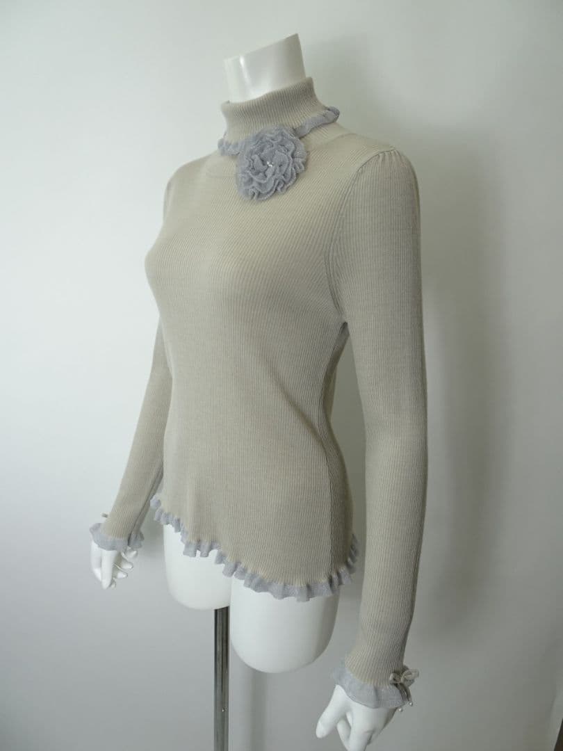 新品】スーパービューティーコサージュ付衿袖先フリルタートルネック